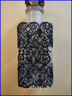 This Vintage French perfume bottle a clear glass body encased In Metal Overlay