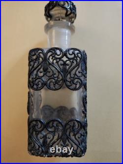 This Vintage French perfume bottle a clear glass body encased In Metal Overlay
